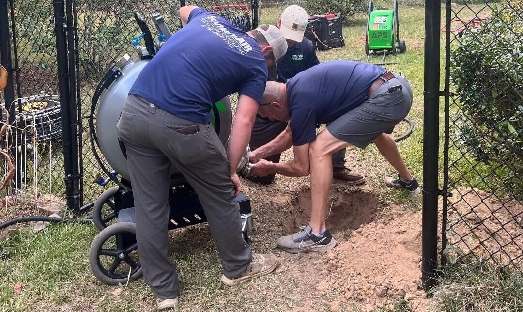 Southern Air techs using a machine for trenchless pipe repair